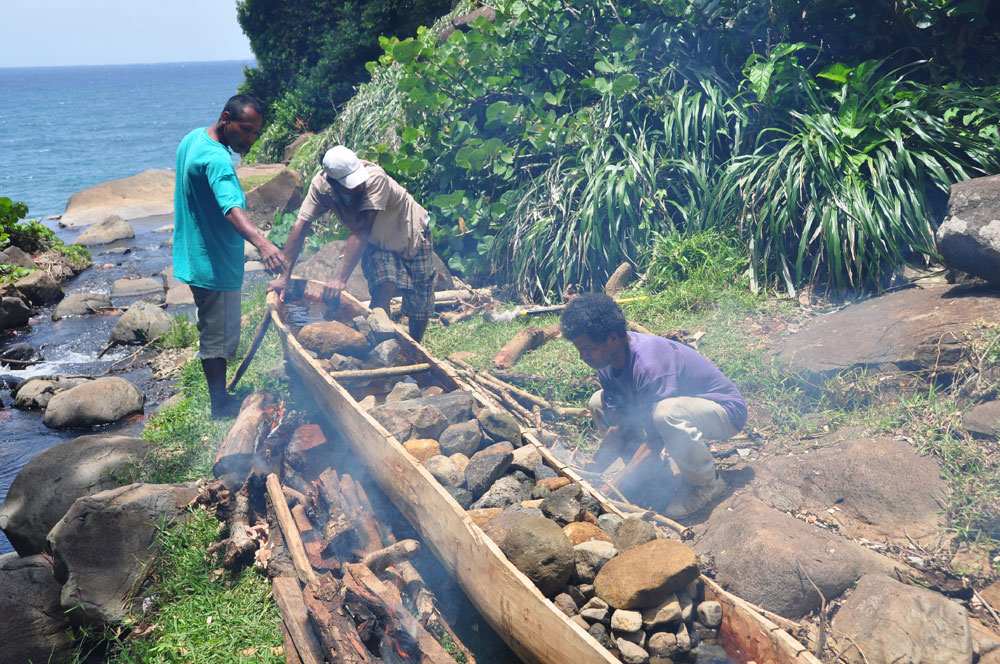 Kalinago Indianer bauen ein traditionelles Kanu